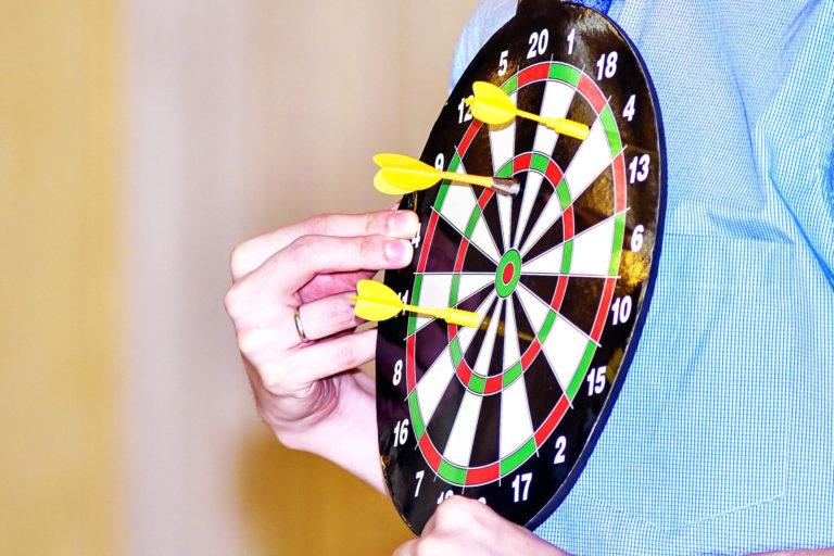 personne qui tient un jeu de fléchettes sur sa poitrine